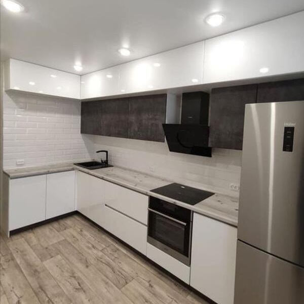 Кухонный гарнитур с сочетанием глянцевой поверхности, дерева и темных оттенков бетона